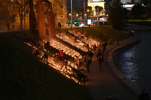Renginį organizavo Vilniaus etninės kultūros centras. Gimnazijos mokiniai dalyvavo rengiant ugnies simbolius, upės kranto šlaite buvo pastatytos ir uždegtos žvakės. - Sputnik Lietuva