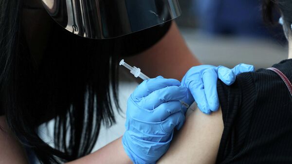 Медработник вводит дозу вакцины от коронавируса - Sputnik Литва