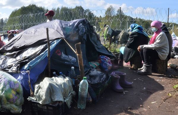 Žmonės nelegalių migrantų iš Afganistano stovykloje, Baltarusijos ir Lenkijos pasienyje. - Sputnik Lietuva