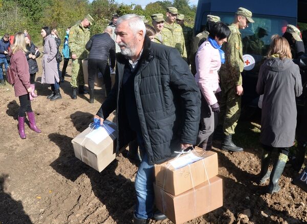 Baltarusijos parlamento narys Tengizas Dumbadzė neša dėžes su humanitarine pagalba pabėgėliams iš Afganistano, įstrigusiems Baltarusijos ir Lenkijos pasienyje. - Sputnik Lietuva
