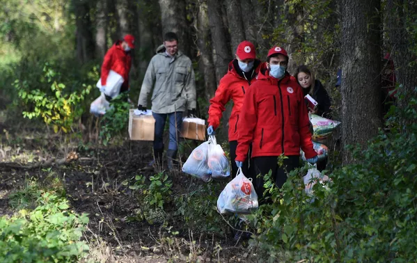 Baltarusijos Raudonojo Kryžiaus ir Baltarusijos moterų sąjungos aktyvistai atneša humanitarinę pagalbą pabėgėliams iš Afganistano, įstrigusiems Baltarusijos ir Lenkijos pasienyje. - Sputnik Lietuva