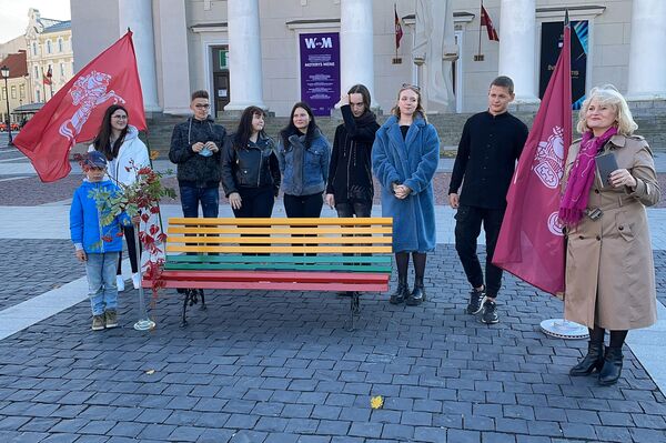 На фото: учительница Астра Астраускайте в окружении учеников стоит у скамейки на Ратушной площади Вильнюса. - Sputnik Литва