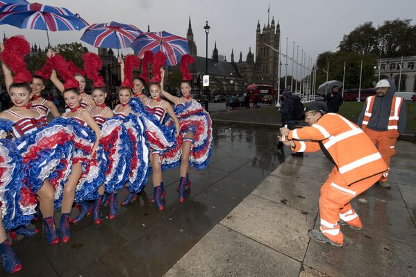 Darbuotojai fotografuoja šokėjas iš garsiosios Paryžiaus &quot;Moulin Rouge&quot; šokių trupės prie Parlamento rūmų, Londone, 2016 metų lapkričio 4 dieną, per reklaminį pokalbį. - Sputnik Lietuva