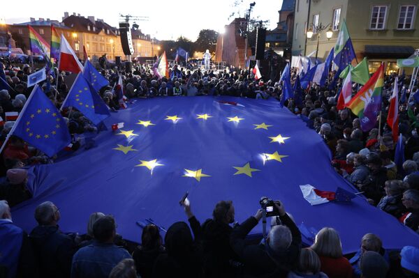 Dalyviai laiko didelę ES vėliavą, dalyvaudami ES pritariančioje demonstracijoje po Konstitucinio Teismo sprendimo prieš ES teisės viršenybę Lenkijoje, Varšuvoje, 2021 metų spalio 10 dieną. Mitinge susirinko dešimtys tūkstančių lenkų, kurie gynė savo šalies narystę ES. Šias demonstracijas sušaukė buvęs ES vadovas Donaldas Tuskas, dabar pagrindinės šalies opozicijos grupuotės &quot;Pilietinė platforma&quot; lyderis, perspėjęs apie &quot;Polexit&quot; perspektyvą. - Sputnik Lietuva