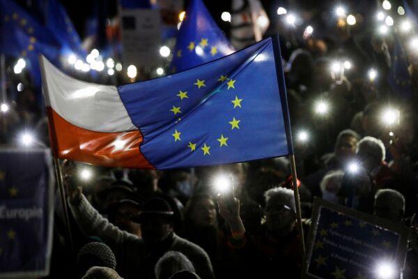 Žmonės mitinge palaiko Lenkijos narystę Europos Sąjungoje, laikydami vėliavas ir uždegdami mobiliuosiuose telefonuose esančią švieselę. - Sputnik Lietuva