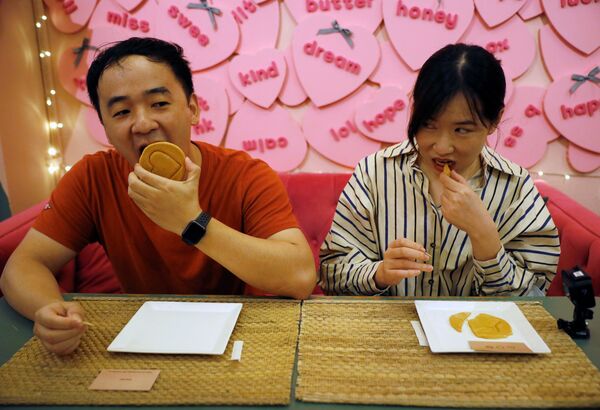 32 metų Wang Chenas ir 27 metų Zhang Qi išbando savo jėgas &quot;sausainio iššūkyje&quot;, rodomame naujame &quot;Netflix&quot; seriale &quot;Squid Game&quot;. - Sputnik Lietuva