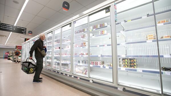 Пожилой покупатель смотрит на пустые полки в супермаркете в Великобритании - Sputnik Литва