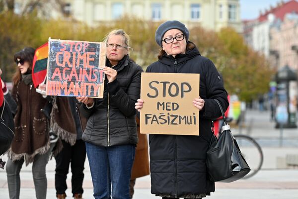 Участницы митинга с плакатами &quot;Стоп преступлениям против человечности&quot; и &quot;Стоп медицинскому фашизму&quot;. - Sputnik Литва