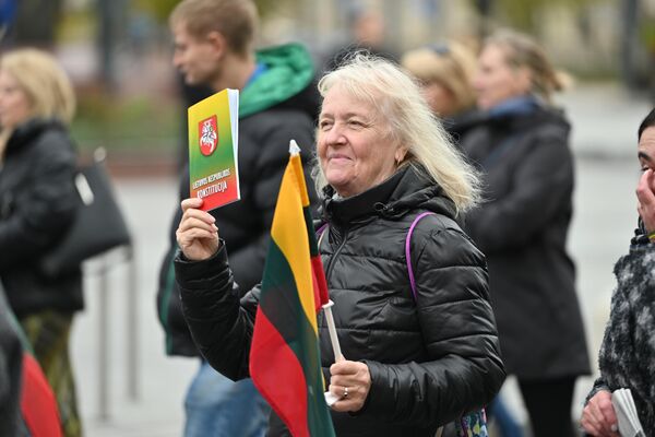 На фото: участница митинга с Конституцией Литвы и национальным флагом. - Sputnik Литва