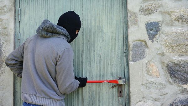 Грабитель вскрывает дверь, архивное фото - Sputnik Литва