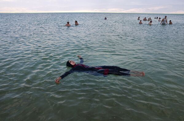 Žmonės laiką leidžia vandenyje Izraelio kurorte Neve Zohar, pietinėje Negyvosios jūros dalyje. - Sputnik Lietuva