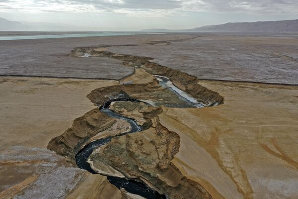 Arabos upė kerta sausą jūros ruožą, sukurdama druskos lygumą pakeliui į pietinę Negyvosios jūros dalį. - Sputnik Lietuva