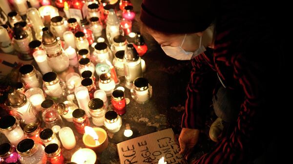 Люди ставят свечи в память о женщине, умершей на 22-й неделе беременности в Польше - Sputnik Литва