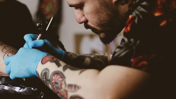 Тату-мастер делает татуировку, архивное фото - Sputnik Lietuva