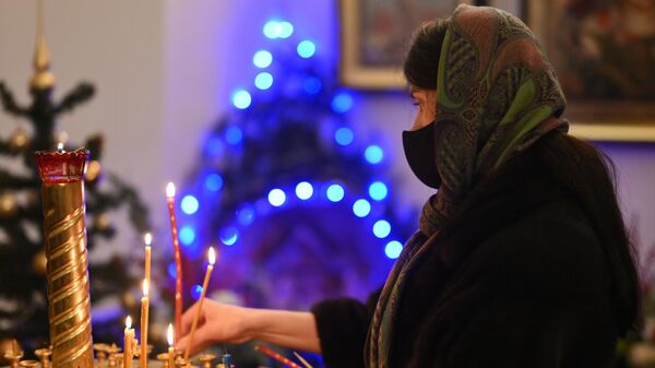 Женщина во время Рождественского богослужения в храме, архивное фото - Sputnik Литва