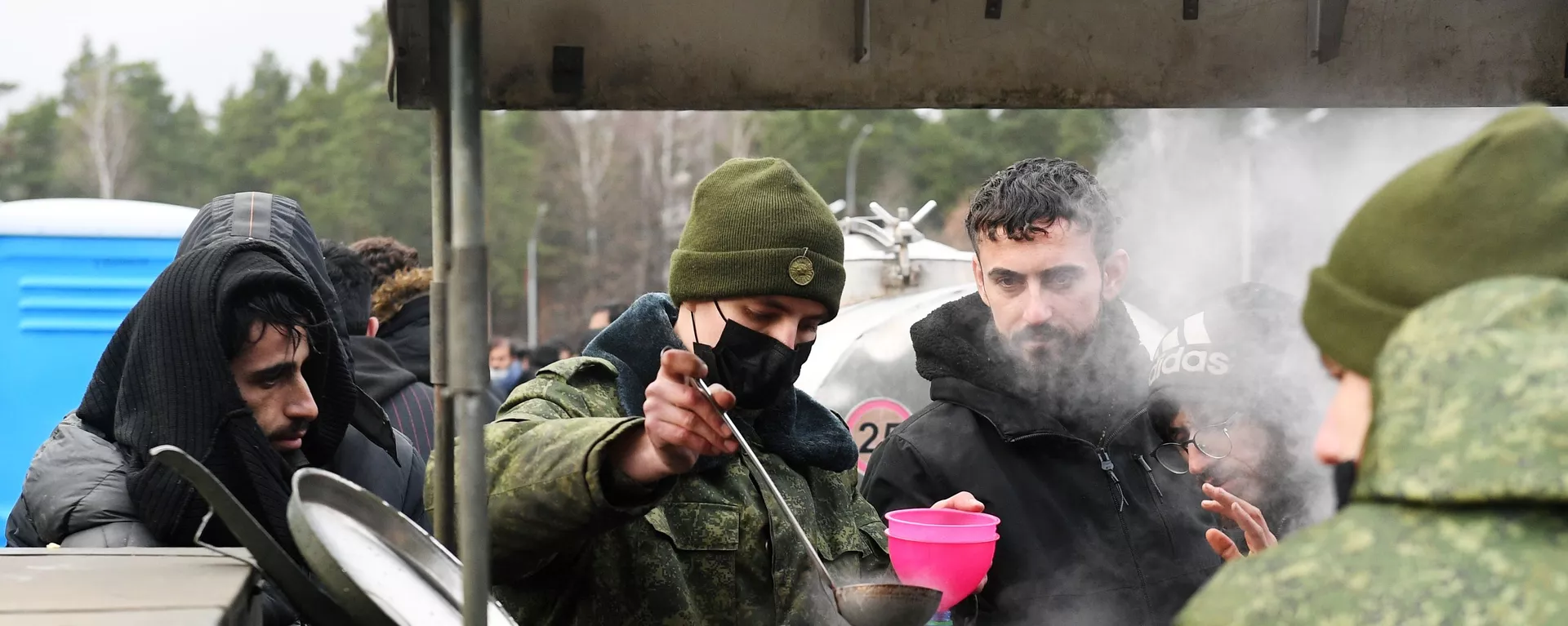 Беженцы с Ближнего Востока набирают кипяток в бутылки возле центра временного содержания мигрантов - Sputnik Lietuva, 1920, 23.11.2021