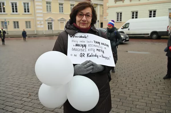 Moteris laiko plakatą su užrašu: &quot;Prezidente, mūsų vaikai laukia tikrų Kalėdų ir Naujųjų ateinančių ir daugybės kitų metų, o ne QR Kalėdų ir Naujųjų!&quot; - Sputnik Lietuva
