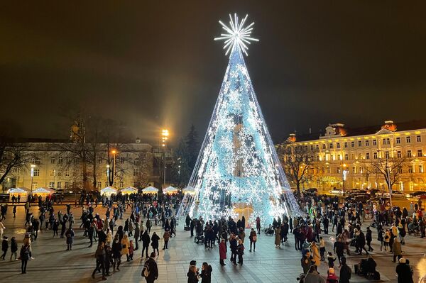 На фото: люди гуляют на Кафедральной площади перед зажженной рождественской елкой.  - Sputnik Литва