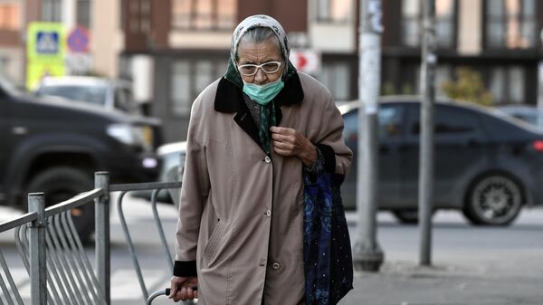 Пожилая женщина идет по улице, архивное фото - Sputnik Литва