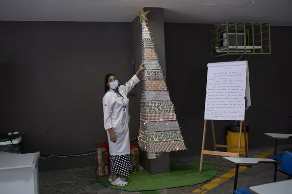 Sveikatos srities specialistė rodo eglutę, pagamintą iš COVID-19 ir gripo vakcinos buteliukų Rio de Žaneire, Brazilijoje. Sveikatos srities specialistė rodo eglutę, pagamintą iš COVID-19 ir gripo vakcinos buteliukų Rio de Žaneire, Brazilijoje. - Sputnik Lietuva