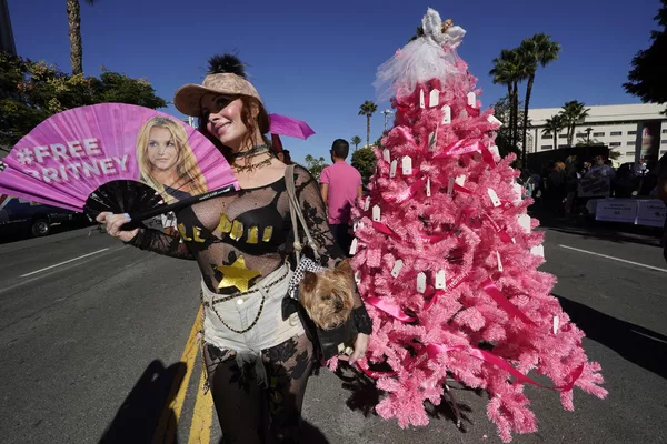 Britney Spears šalininkė Phoebe Price ir jos šuo Henris fotografuojasi prie "Free Britney" Kalėdų eglės, kurią jos gerbėjai pastatė po teismo posėdžio dėl pop dainininkės globos Stanley Mosko teismo rūmuose, Los Andžele. Los Andželo teisėjas nutraukė globą, kurią turėjęs atlikėjos tėvas beveik 14 metų kontroliavo Spears gyvenimą ir pinigus. Britney Spears šalininkė Phoebe Price ir jos šuo Henris fotografuojasi prie "Free Britney" Kalėdų eglės, kurią jos gerbėjai pastatė po teismo posėdžio dėl pop dainininkės globos Stanley Mosko teismo rūmuose, Los Andžele. Los Andželo teisėjas nutraukė globą, kurią turėjęs atlikėjos tėvas beveik 14 metų kontroliavo Spears gyvenimą ir pinigus. - Sputnik Lietuva