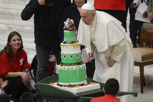 2019 metų gruodžio 22 dieną, sekmadienį, Vatikano Pauliaus VI salėje, popiežius Pranciškus pučia žvakutę ant gimtadienio torto, kurį jam įteikė Šv. Mortos ambulatorijos vaikai. - Sputnik Lietuva