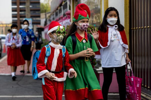 Vaikai, pasipuošę šventiniais drabužiais, eina į mokyklos Kalėdinę šventę Ajutajoje, Tailande. - Sputnik Lietuva