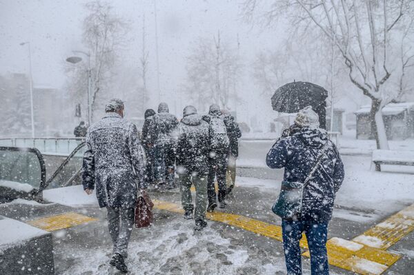 2021 metų vasario 17 dieną ankstų rytą žmonės eina per smarkią sniego audrą Stambulo Kadikoy rajone. - Sputnik Lietuva
