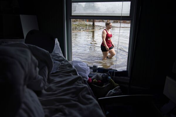 Emily Francois vaikšto per potvynių vandenis šalia savo namų, kuriuos potvynis apgadino po uragano Ida, 2021 metų rugsėjo 1 dieną, Jean Lafitte mieste. - Sputnik Lietuva
