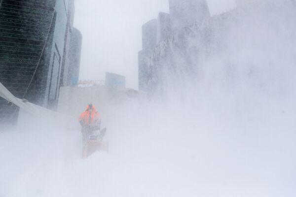 Savivaldybės tarnybos darbuotojas šalina sniegą iš aikštės prie Maskvos miesto verslo centro. - Sputnik Lietuva