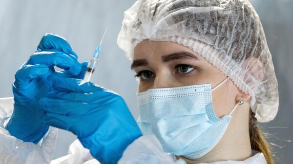 Медицинский работник готовит дозу вакцины от коронавируса, архивное фото - Sputnik Литва