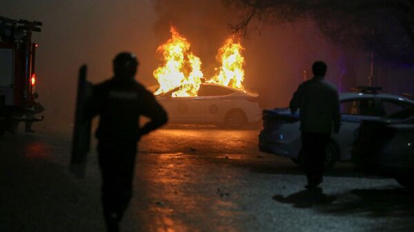 Degantis policijos automobilis per protestą prieš dujų kainų kilimą Almatoje - Sputnik Lietuva
