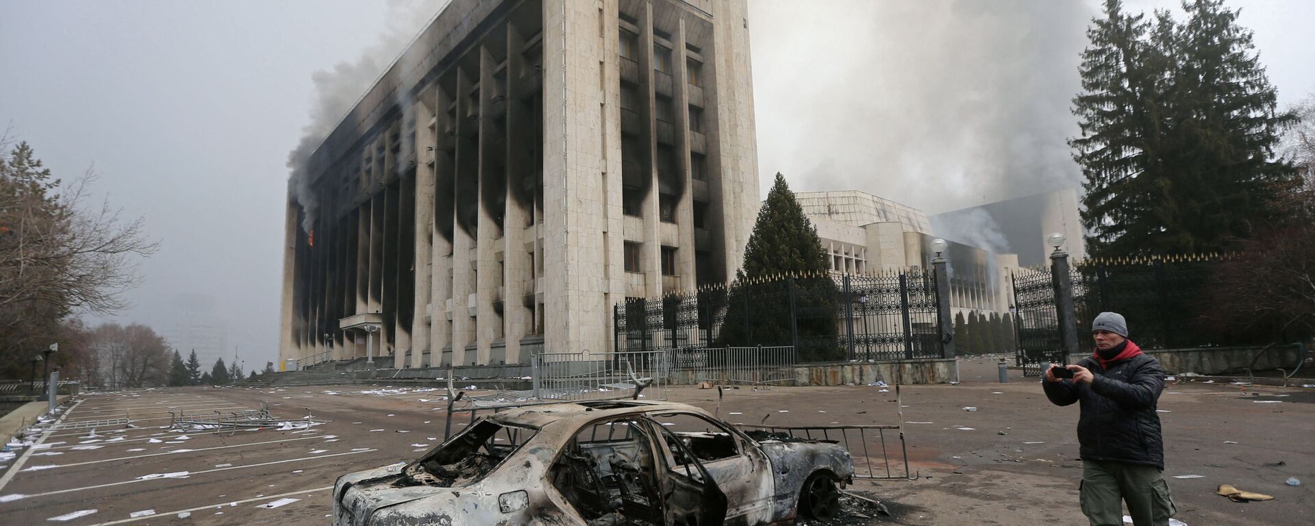 Сгоревший автомобиль перед зданием мэрии, которое было подожжено во время протестов в Алматы - Sputnik Lietuva, 1920, 10.01.2022