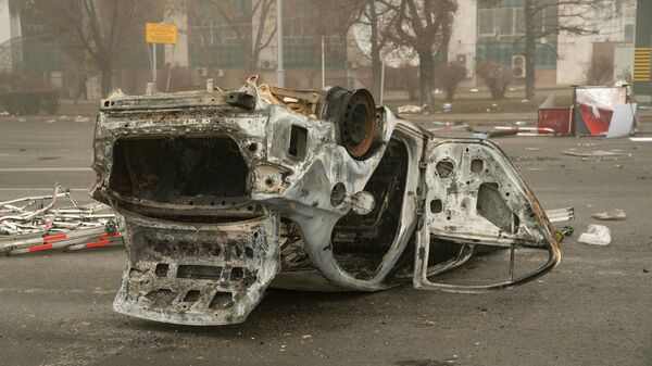 Сгоревший автомобиль на площади возле административного квартала в центре Алматы - Sputnik Литва