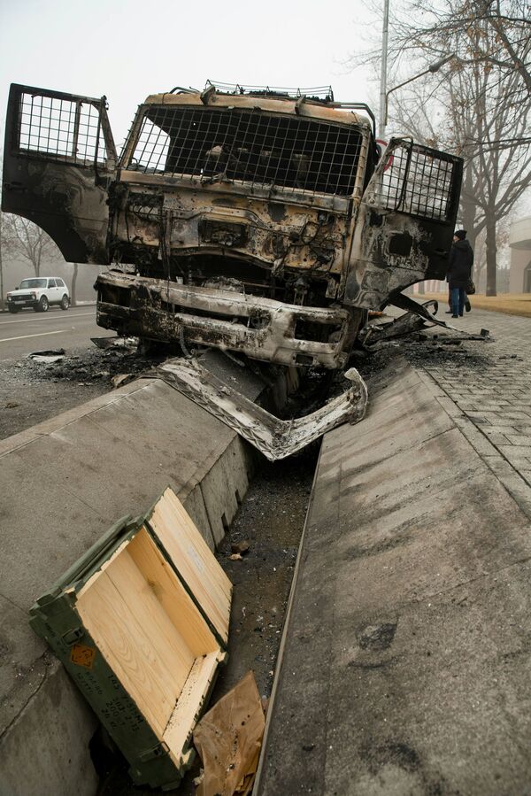 Nuotraukoje pavaizduotas sudegęs policijos automobilis vienoje gatvėje Almatos centre. - Sputnik Lietuva
