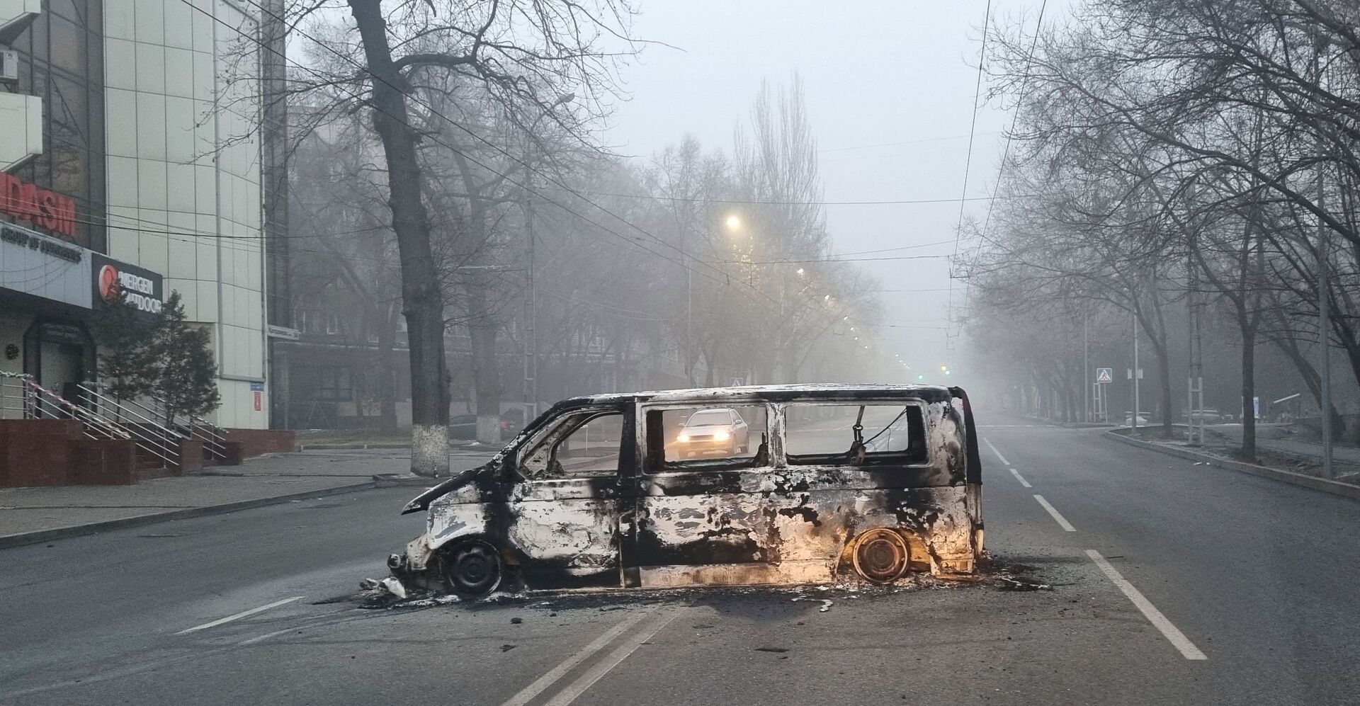 Автомобиль, сожженный во время протестов, вызванных повышением цен на топливо, на дороге в Алматы - Sputnik Lietuva, 1920, 11.01.2022