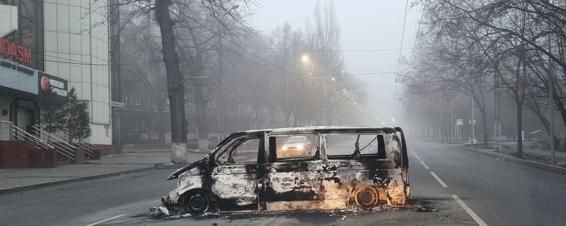Автомобиль, сожженный во время протестов, вызванных повышением цен на топливо, на дороге в Алматы - Sputnik Литва, 1920, 10.01.2022