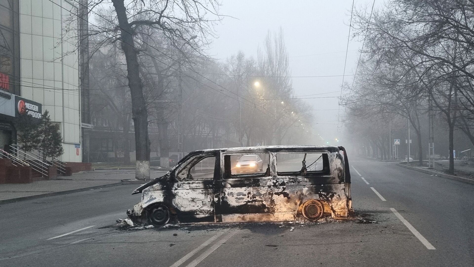 Автомобиль, сожженный во время протестов, вызванных повышением цен на топливо, на дороге в Алматы - Sputnik Lietuva, 1920, 10.01.2022