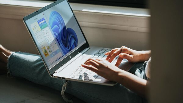 Žmogus dirba nešiojamuoju kompiuteriu su Windows 11 operacine sistema - Sputnik Lietuva