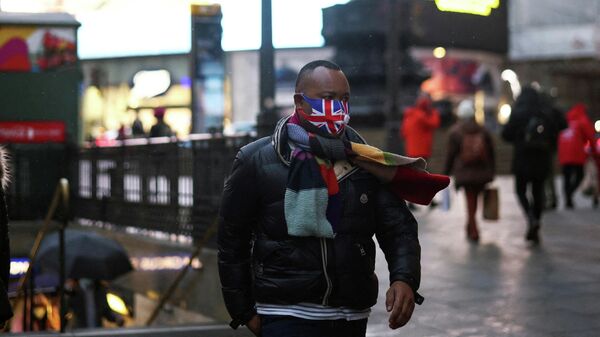 Мужчина в защитной маске на площади Пикадилли в Лондоне - Sputnik Lietuva