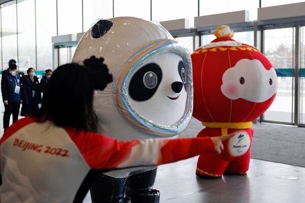 Darbuotojai dėvi 2022 metų Pekino olimpinių ir parolimpinių žiemos žaidynių talismanų Bing Dwen Dwen ir Shuey Rhon Rhon kostiumus pagrindiniame žiniasklaidos centre Pekine, Kinijoje, 2022 metų sausio 30 dieną. - Sputnik Lietuva
