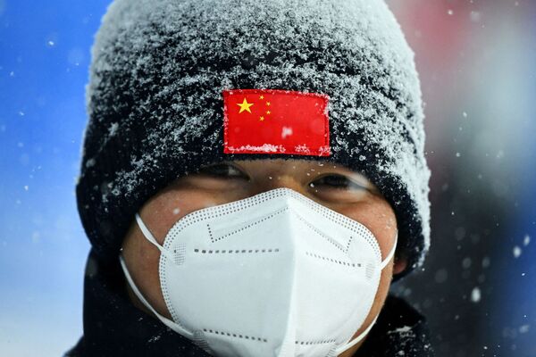 Policininkas stovi sargyboje sniego audros metu per vyrų slidinėjimo rungtynes Zhangjiakou Genting sniego parke prieš 2022 metų Pekino žiemos olimpinių žaidynių laisvojo slidinėjimo varžybas Čangdziakou mieste, Kinijoje, 2022 metų sausio 30 dieną. - Sputnik Lietuva
