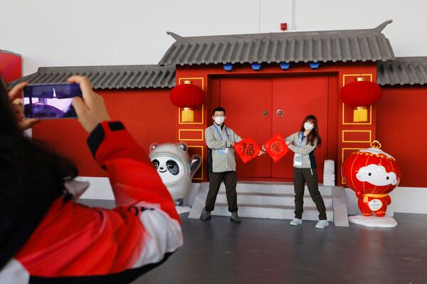 Darbuotojai pozuoja su &quot;Fai Chun&quot;, tradicine kinų Naujųjų metų puošmena, pagrindiniame žiniasklaidos centre. - Sputnik Lietuva