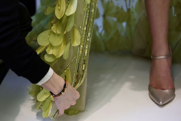 Asistentė koreguoja suknelę prieš Elie Saab Haute Couture 2022 metų pavasario-vasaros kolekcijos parodą Paryžiuje. - Sputnik Lietuva