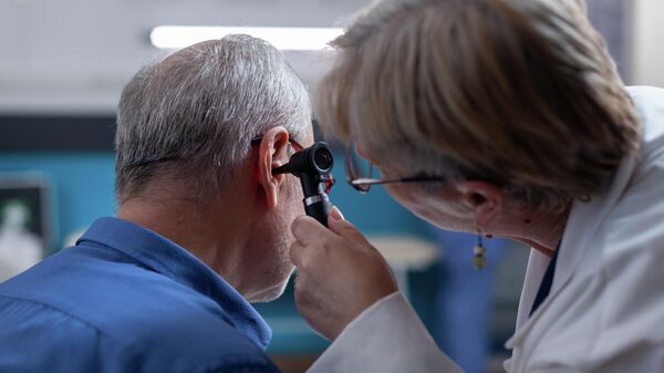 Gydytojas otorinolaringologas apžiūri paciento ausį - Sputnik Lietuva