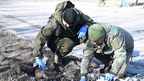 DLR liaudies milicijos pareigūnai apžiūri sprogimo vietą Donecke po apšaudymo - Sputnik Lietuva