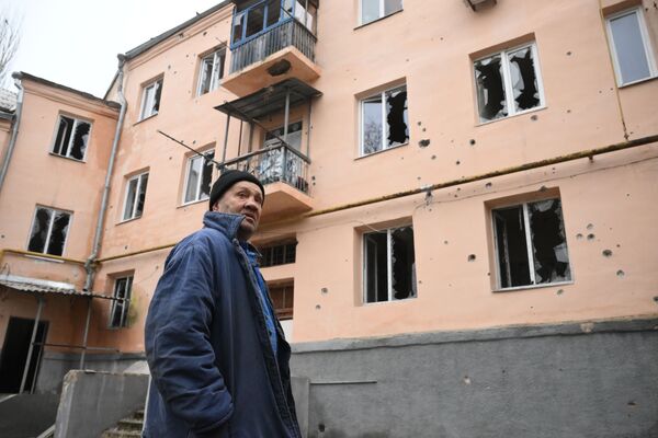 Tuo tarpu Ukrainos ginkluotosios pajėgos toliau apšaudo civilius objektus, kuriuose gali būti civilių gyventojų. Nuotraukoje: vyras Donecko Kijevo rajone prie namo, kuris buvo apšaudytas. - Sputnik Lietuva