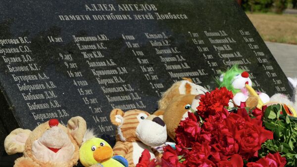Gėlės ir žaislai padėtos prie paminklo Angelų alėja Donecke - Sputnik Lietuva