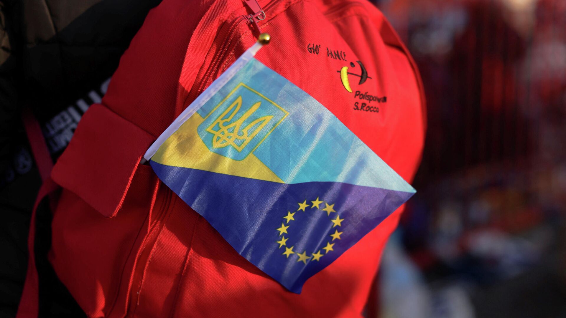 Ant ukrainiečio pabėgėlio kuprinės vėliavėlė su Ukrainos ir Europos Sąjungos simboliais - Sputnik Lietuva, 1920, 20.03.2022