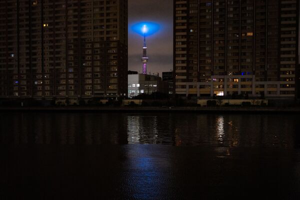 Tokyo Skytree (C) pavaizduotas tarp užtemdyto gyvenamojo rajono nutrūkus elektros tiekimui. - Sputnik Lietuva